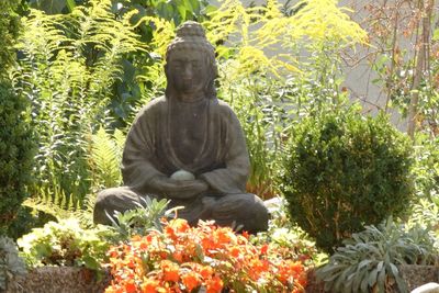 Statue amidst plants in garden