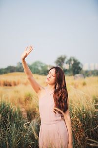 Woman standing on field against sky