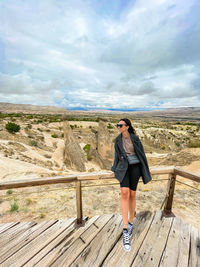 Full length of woman standing on railroad track against sky