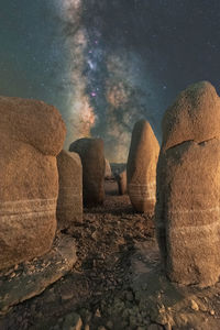 Picturesque view of spanish stonehenge on rough terrain under sunset sky with galaxy in caceres spain