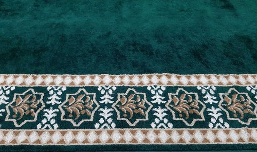 High angle view of green carpet with floral patterns