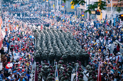 High angle view of army marching amidst crowd in city