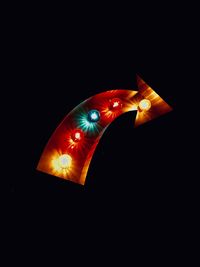 Low angle view of illuminated light bulb against black background