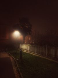 Illuminated road against sky at night