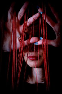 Woman behind tangled threads between finger