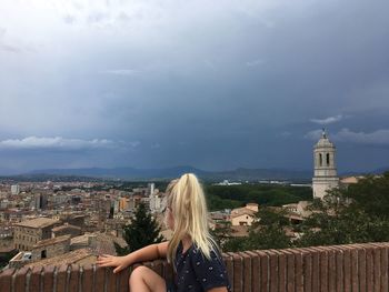 Midsection of woman against sky in city