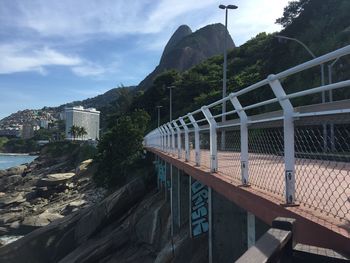 Bridge over mountain against sky