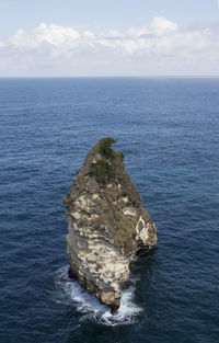 Rock formation in sea against sky