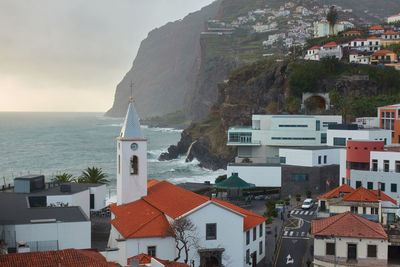 Townscape by sea against sky in town