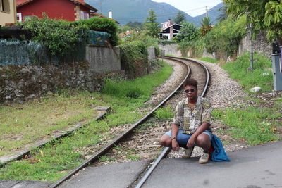 Woman sitting on railroad track
