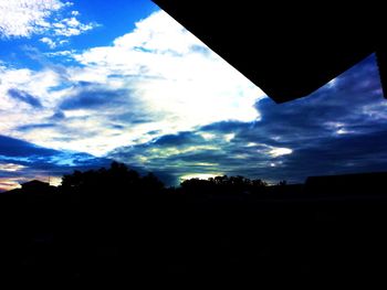 Silhouette of building against cloudy sky