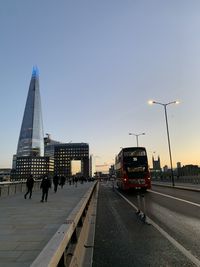 People walking on road in city at sunset