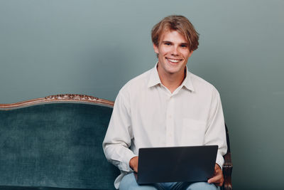 Portrait of smiling young man using mobile phone