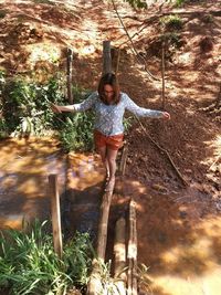 Full length portrait of happy young woman in forest