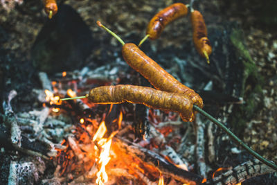 Close-up of sausages over bonfire