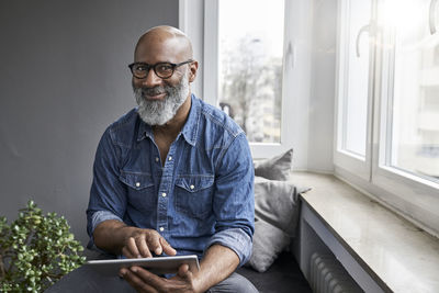 Mature man sitting at window