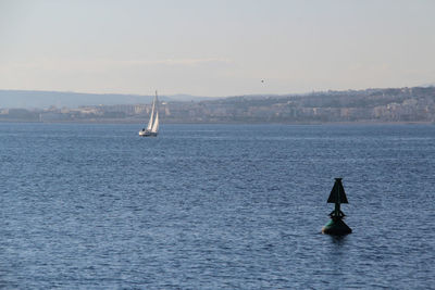 Sailboat sailing on sea against clear sky