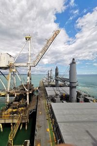 Commercial dock by sea against sky