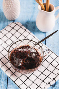 Homemade sweet cake in a mug made in the microwave on the table vertical view