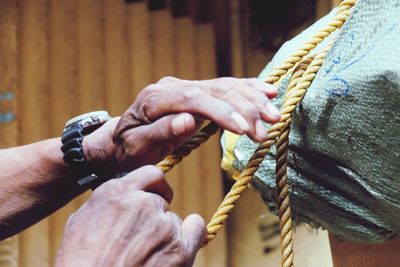 Close-up of hands tied to rope