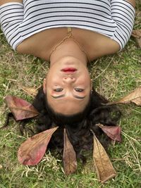 High angle portrait of woman lying on grass