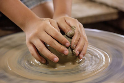 Cropped hands of woman molding mud