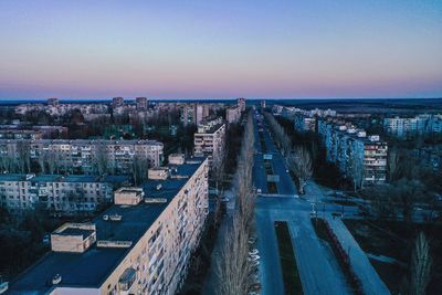 High angle view of road by buildings against sky during sunset