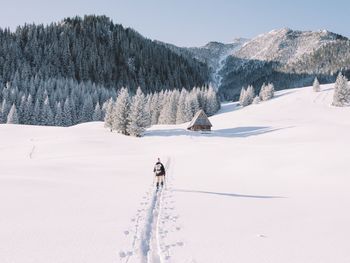 PERSON SKIING BY SNOW AGAINST SKY