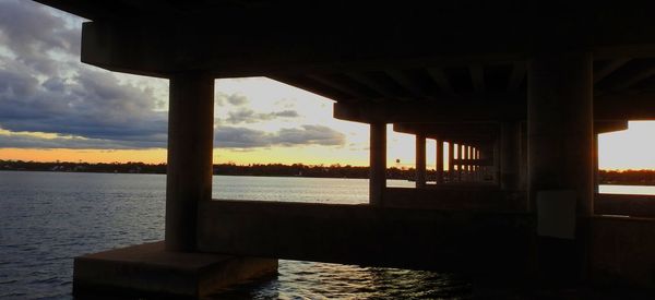 Bridge over sea against sky during sunset