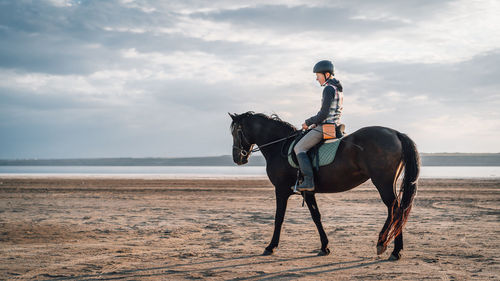 Man riding horse on beach