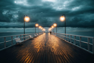 Pier over sea against sky during sunset