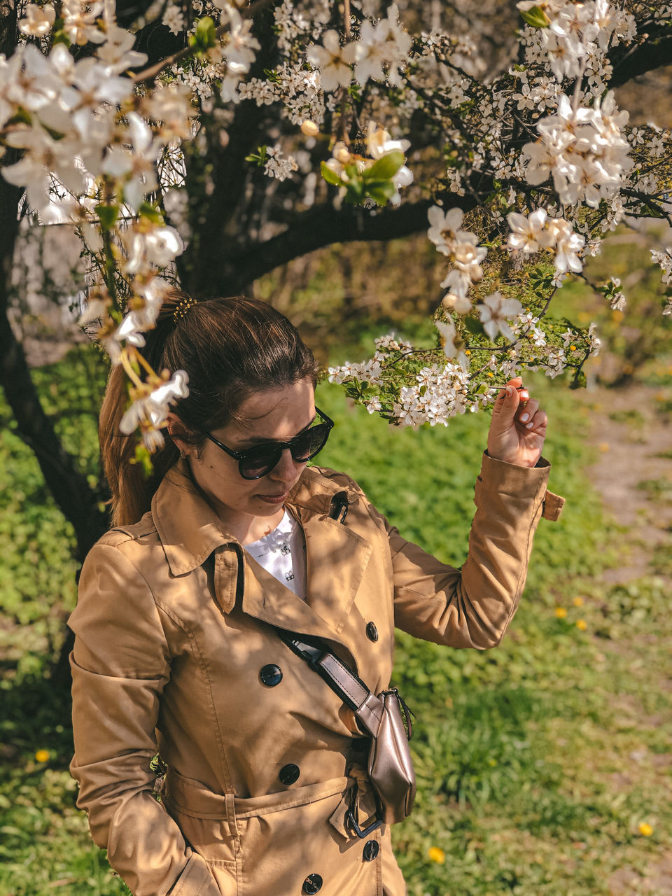 one person, plant, real people, standing, nature, glasses, leisure activity, flower, flowering plant, tree, lifestyles, front view, day, sunlight, young adult, waist up, young women, focus on foreground, fashion, outdoors, hairstyle