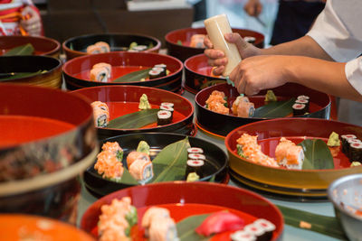 Midsection of chef preparing sushi in commercial kitchen 