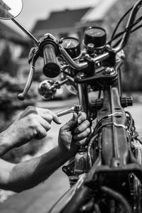 Cropped hand repairing motorcycle