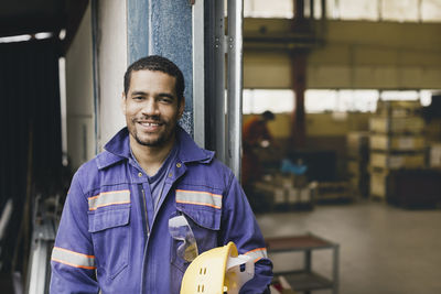 Portrait of confident male worker in protective workwear at factory