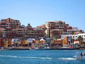 Boats in river with buildings in background