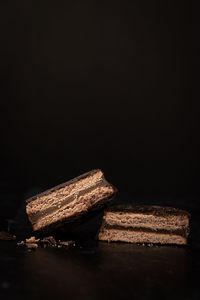 Close-up of chocolate cake on wood against black background