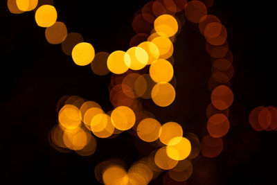 Defocused image of illuminated orange lights at night