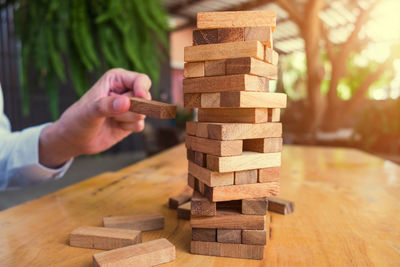 Cropped image of business person playing block removal game on table