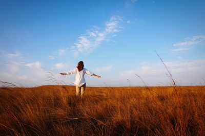 Full length of man standing on field against sky