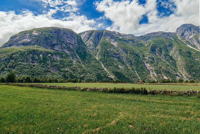 Scenic view of field and mountains against sky