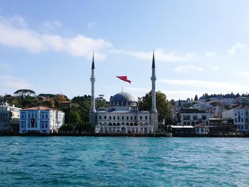 Mosque at waterfront against sky