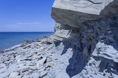 View of rock formation on sea shore against sky