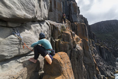 Rear view of friends standing on rock