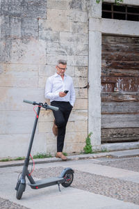 Young businessman using phone near electric scooter. focus on scooter