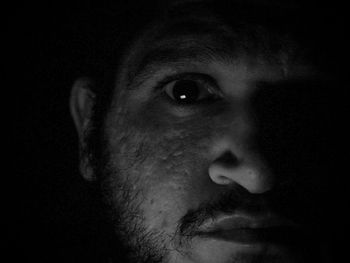 Close-up portrait of young man against black background