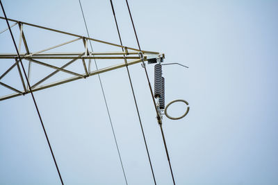 Low angle view of electricity pylon against clear sky