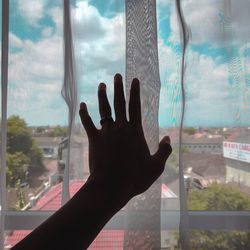 Cropped hand touching curtain