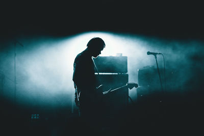 Silhouette man standing at music concert