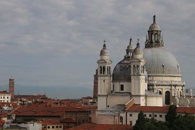 View of buildings in city against cloudy sky